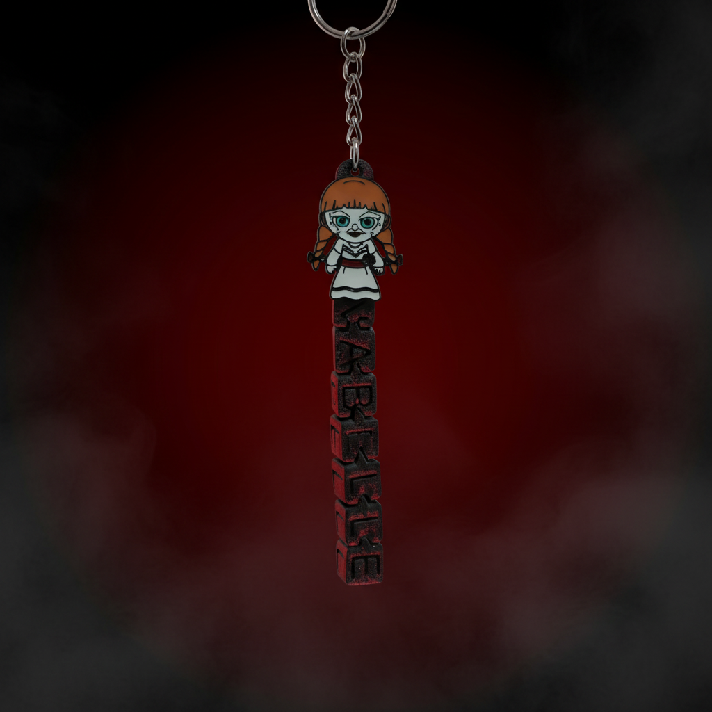 Chibi Annabelle keychain with bold ANNABELLE horror lettering on blood red dark background