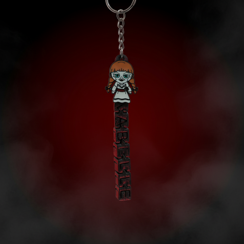 Chibi Annabelle keychain with bold ANNABELLE horror lettering on blood red dark background