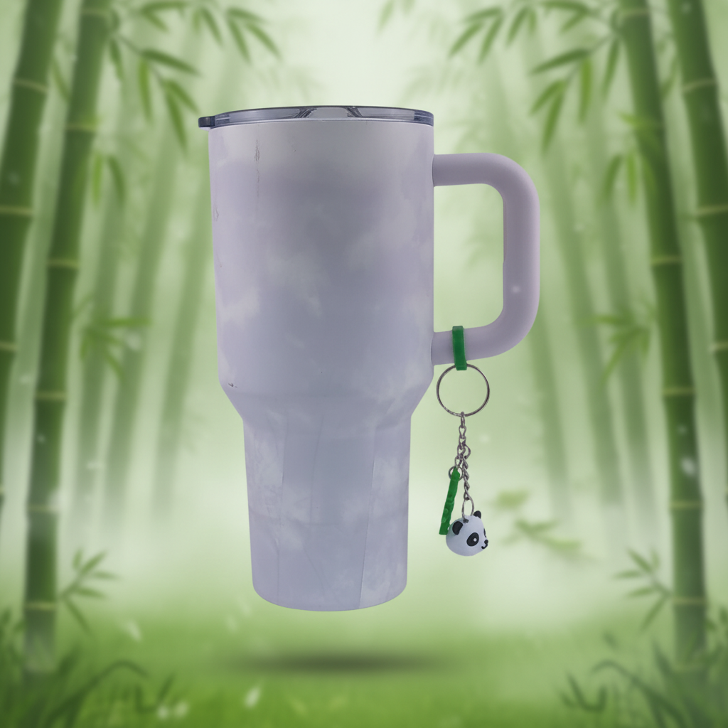 Panda keychain charm hanging on tumbler on green bamboo background