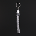 Chibi Slender Man keychain with SLENDER MAN silver text tag on dark charcoal background